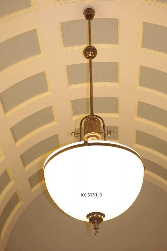 A huge brass chandelier for luxurious foyer or library, with hoops heated to high temperatures and twisted into circles. Custom-made shades tailored to fit. Handcrafted in the Kostylo atelier, polished to a high gloss for striking impression