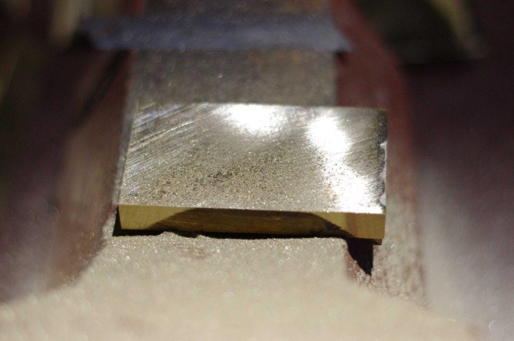 how_we_create_luxurious_trouser_belt_buckle_we_silver_solder_it_into_appropriate_buckle_shapes_then_hand_grind_it_by_kostylo_atelier manual grinding of trouser buckle after silver soldering in the Kostylo atelier