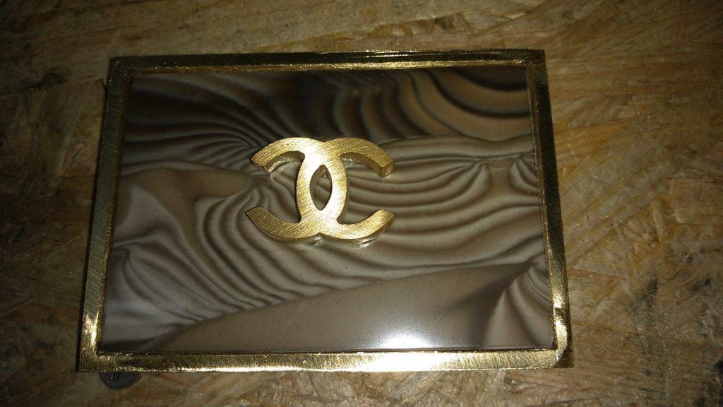 how_we_create_rare_striped_flint_and_the_coco_chanel_logo_into_the_buckle_hand_crafted_by_kostylo_atelier fitted rare striped flint and the coco chanel logo into silver-soldered belt buckle before processing in the Kostylo atelier