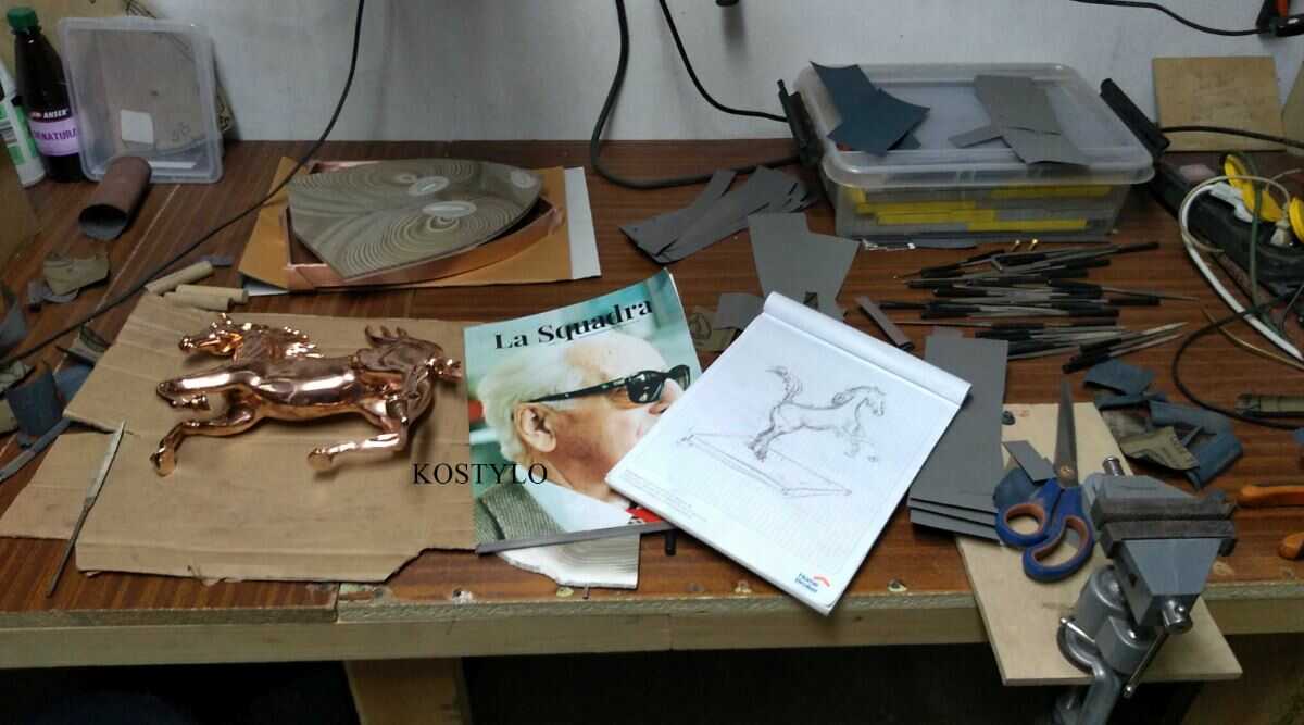 how_we_create_the_sculpture_of_ferrari_horse_preparing_the_horse_sculpture_and_base_with_the_ferrari_logo_for_silver_plating_at_kostylo_atelier from sketch to copper-plated sculpture figure, prepared sculpture of Ferrari horse with copper-plated base in the shape of the Ferrari coat of arms, ready for silver plating in the Kostylo atelier