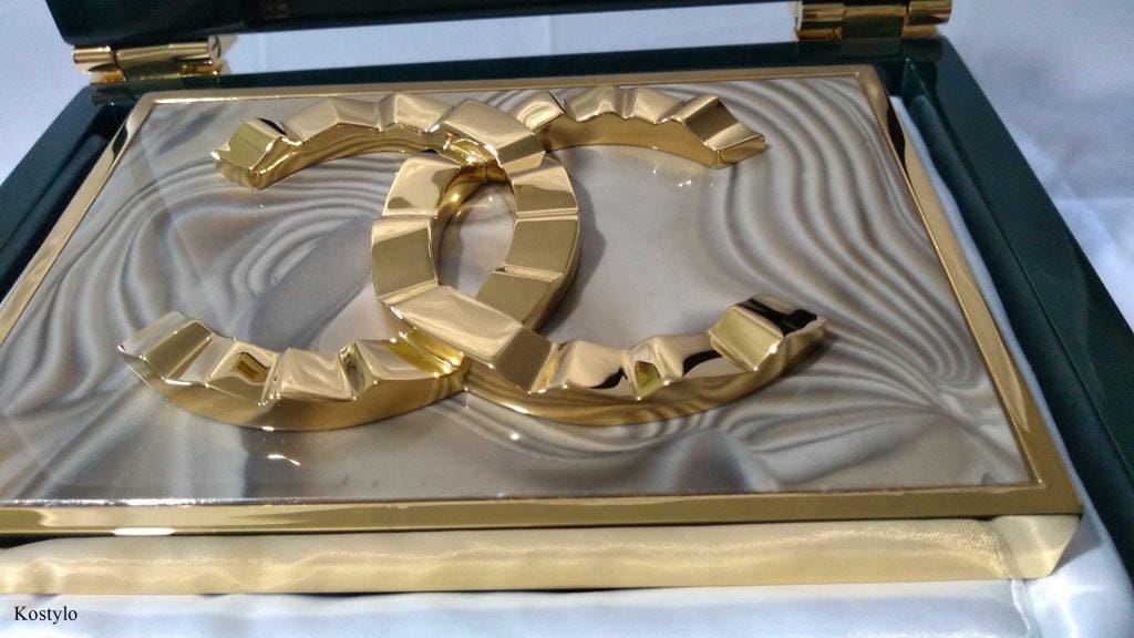 luxury_goldplated_handmade_belt_buckle_coco_chanel_by_kostylo_atelier Closeup of unique luxury gold-plated dress buckle with striped flint and the original gold Coco Chanel logo by Kostylo atelier